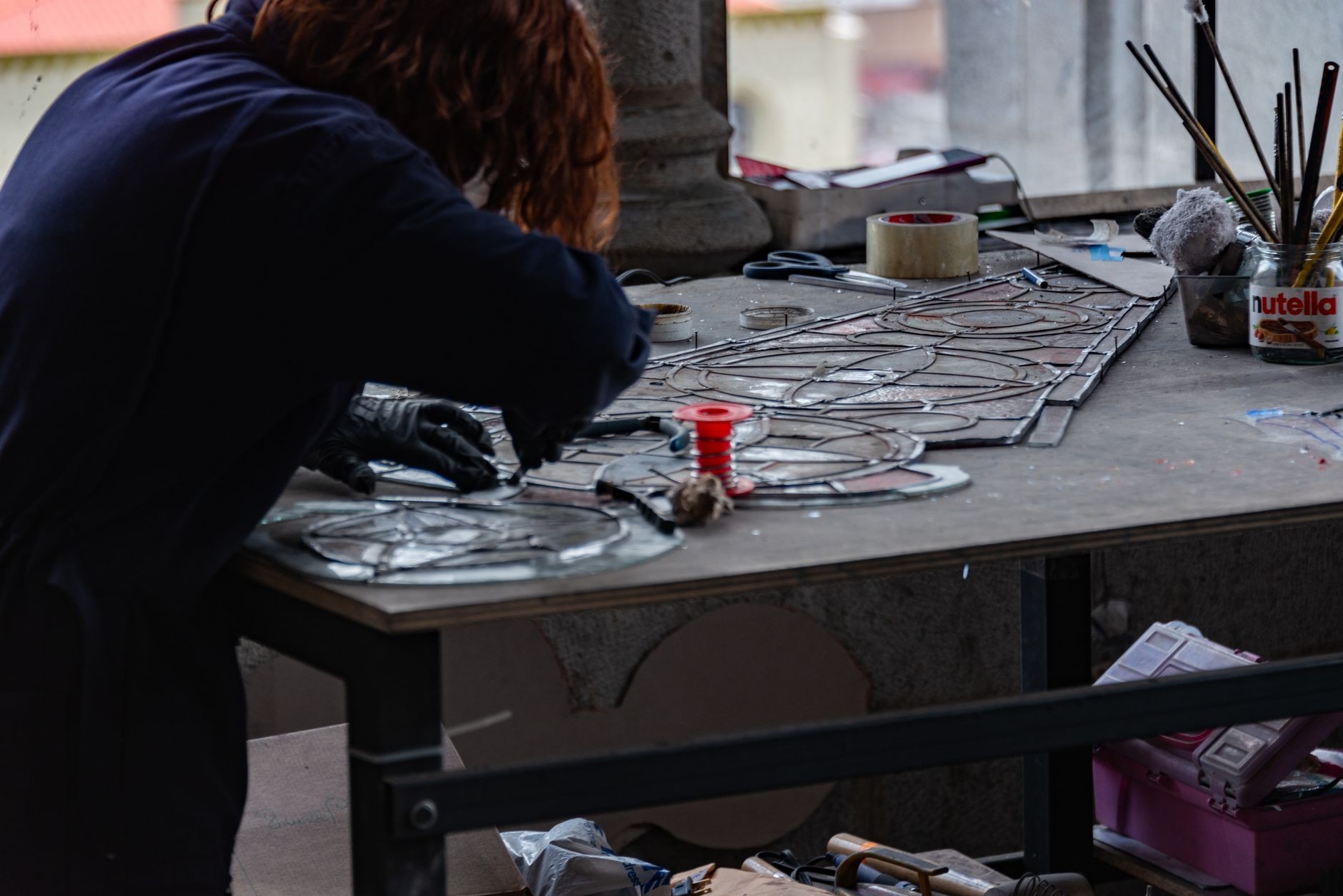 Artisan hand-painting lettering on wooden menu board at Spinwinera workshop